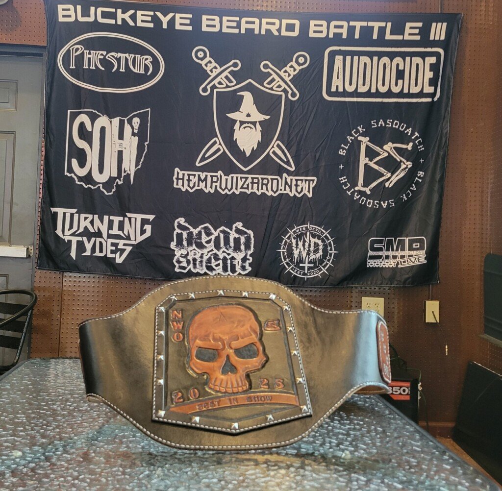 The Buckeye Beard Battle banner hangs on the stage of The Barn behind the championship belt. The beard competition is Saturday at 1 p.m. with proceeds going to Combat to Kayaks.