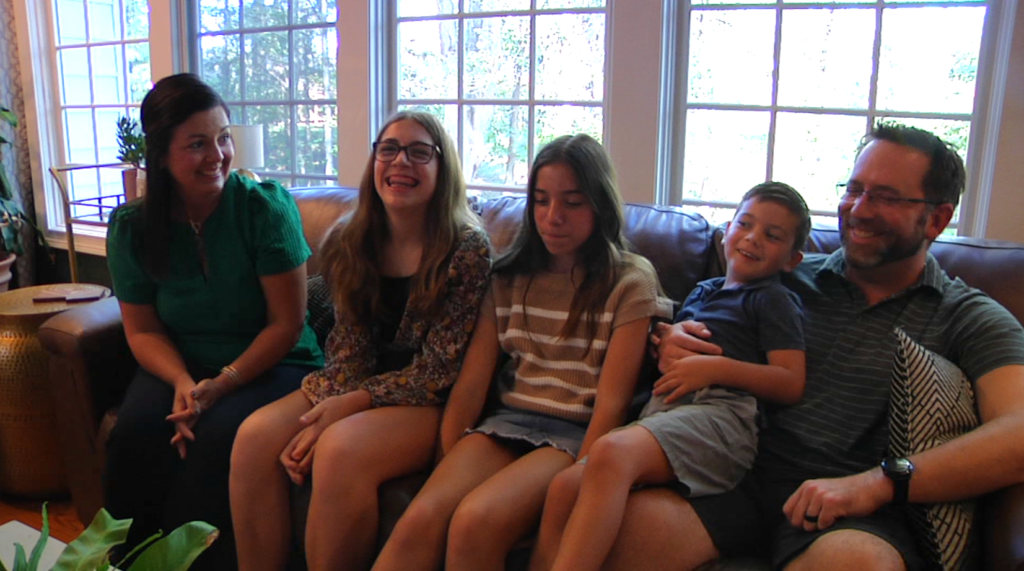Adam and Kali bookend the couch with their three children who sit in the middle.The Burkhart family sits on their couch reflecting on the family they have thanks to an organ donor who saved Adams life.
